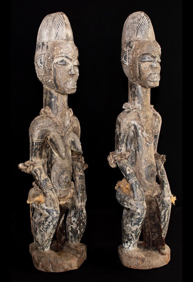 Statue couple Igbo du Nigéria, une pièce ancienne d’art africain destinée aux collectionneurs et amateurs de sculptures traditionnelles. Cet ensemble représentant un couple assis se distingue par son bois dense, sa patine croûteuse, ses dimensions imposantes et sa provenance historique. Une œuvre de caractère pour enrichir une collection d’objets d’art africain.